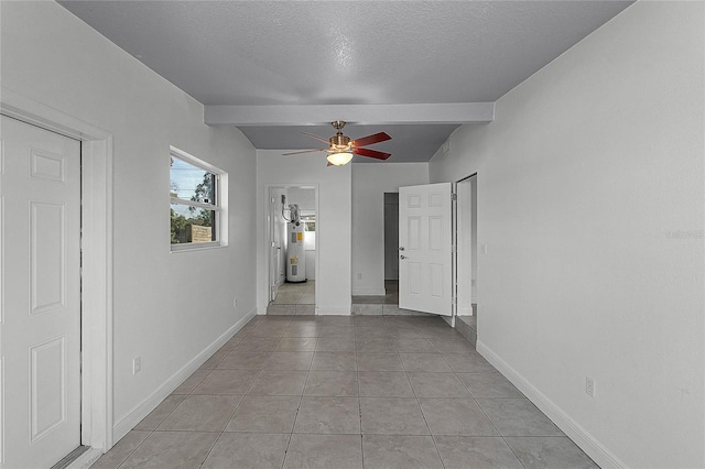 interior space with beamed ceiling, electric water heater, a textured ceiling, and light tile patterned floors