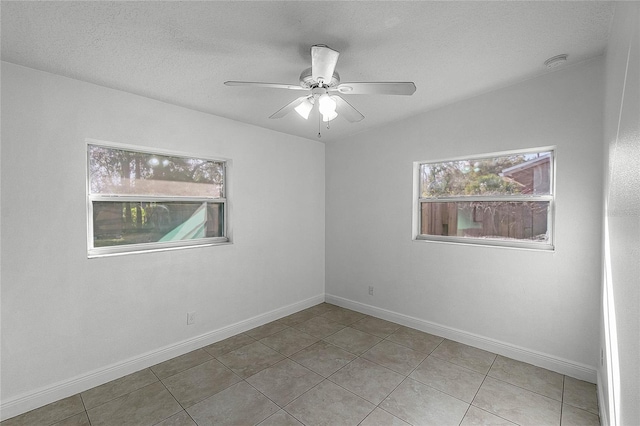 spare room with light tile patterned floors, a textured ceiling, and ceiling fan