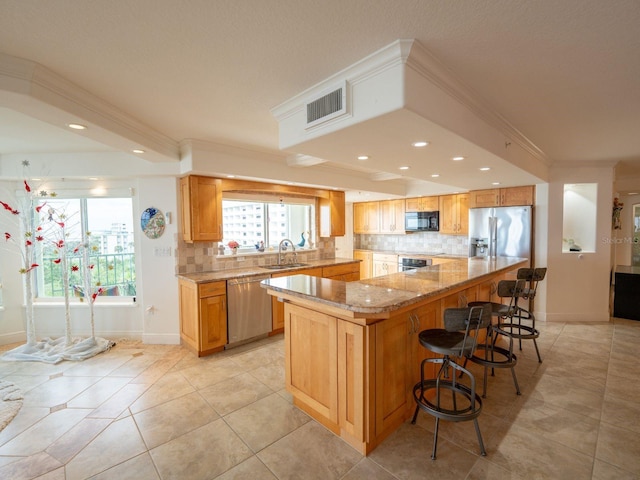 kitchen featuring a kitchen island, ornamental molding, appliances with stainless steel finishes, and tasteful backsplash