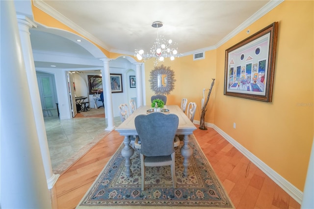 dining area with decorative columns, crown molding, light hardwood / wood-style floors, and a notable chandelier