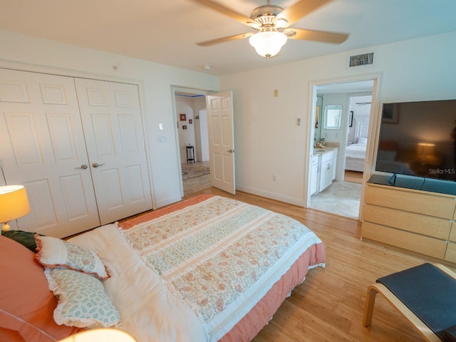 bedroom featuring ceiling fan, a closet, connected bathroom, and light hardwood / wood-style flooring