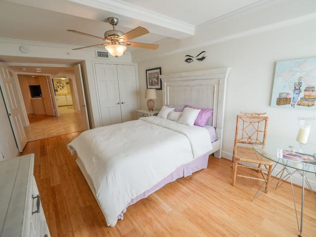 bedroom with light wood-type flooring, a closet, ceiling fan, and crown molding