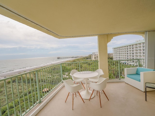 balcony featuring a beach view and a water view