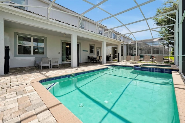 view of pool with glass enclosure and a patio area