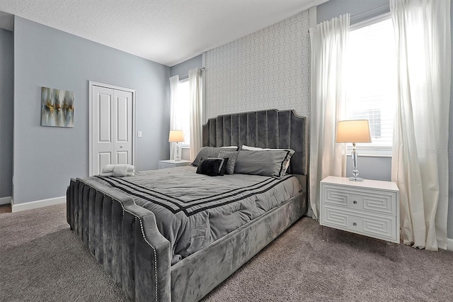 carpeted bedroom with a textured ceiling and a closet