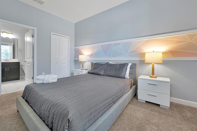 carpeted bedroom with ensuite bathroom, a closet, and sink