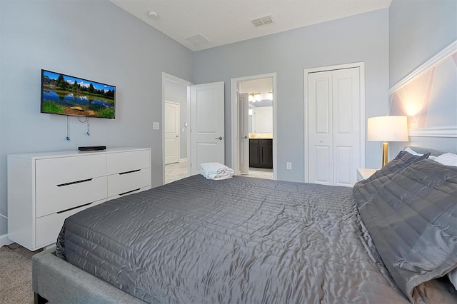 bedroom with light colored carpet, connected bathroom, and a closet