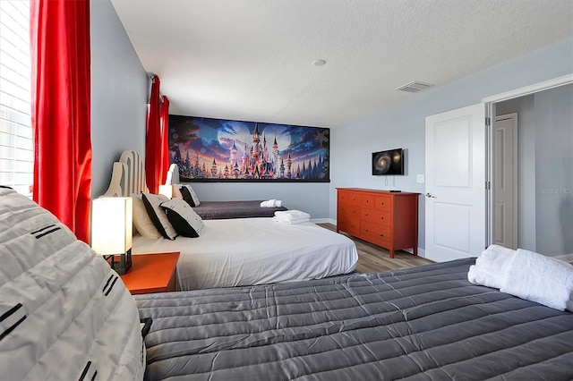 bedroom featuring hardwood / wood-style floors and a textured ceiling