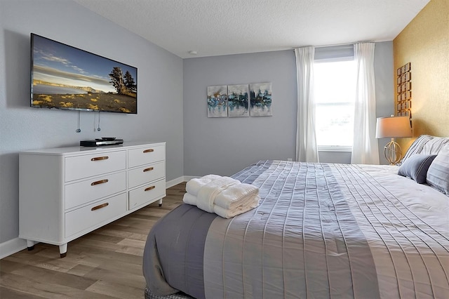 bedroom featuring a textured ceiling and light hardwood / wood-style flooring