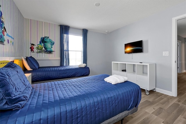 bedroom featuring hardwood / wood-style floors and a textured ceiling