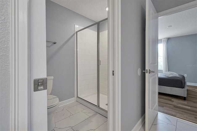 bathroom with a textured ceiling, toilet, walk in shower, and hardwood / wood-style floors