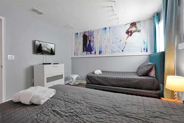 bedroom featuring hardwood / wood-style floors and a textured ceiling