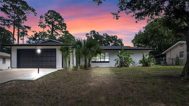 single story home with a garage and a yard