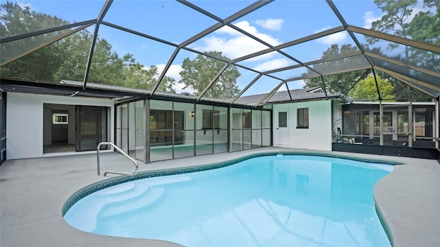 view of swimming pool featuring glass enclosure, a sunroom, and a patio area