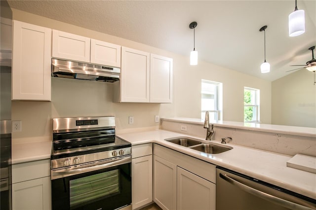 kitchen featuring appliances with stainless steel finishes, white cabinetry, pendant lighting, and sink