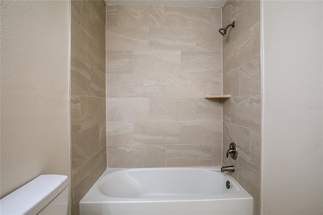 bathroom with tiled shower / bath combo and toilet