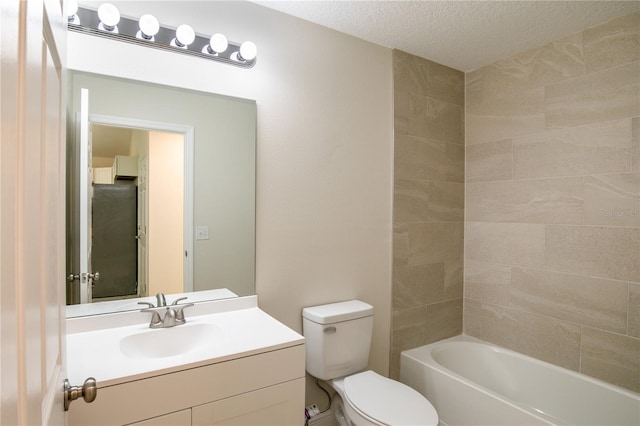 full bathroom with tiled shower / bath, vanity, a textured ceiling, and toilet