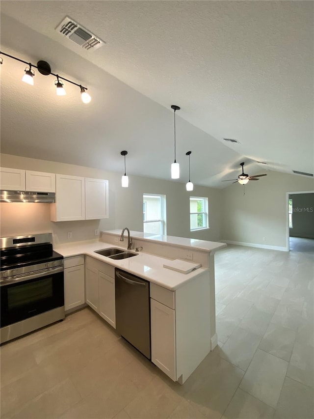 kitchen featuring white cabinets, appliances with stainless steel finishes, lofted ceiling, and sink