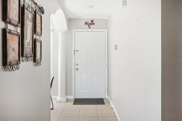 doorway to outside featuring decorative columns and light tile patterned flooring