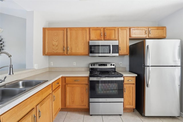 kitchen with light tile patterned floors, sink, and appliances with stainless steel finishes