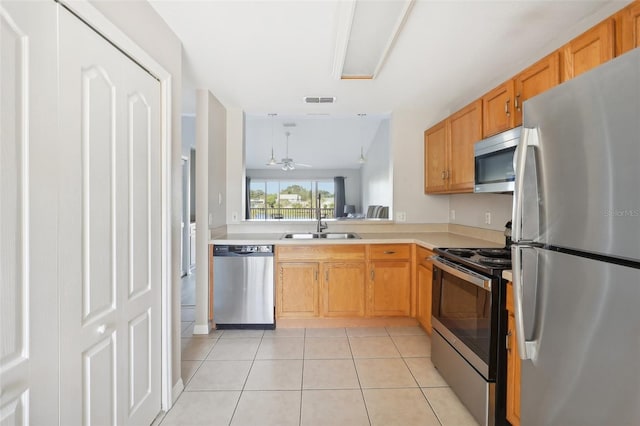 kitchen with ceiling fan, sink, stainless steel appliances, vaulted ceiling, and light tile patterned flooring