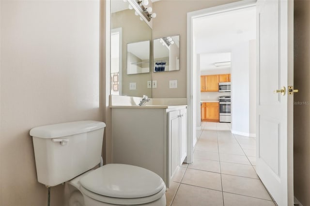 bathroom with tile patterned flooring, vanity, and toilet