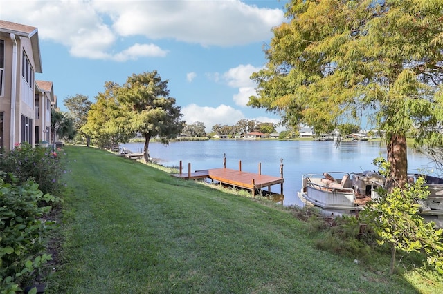 dock area with a water view and a lawn