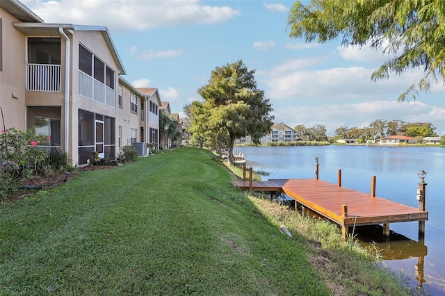 dock area with central air condition unit, a water view, and a lawn