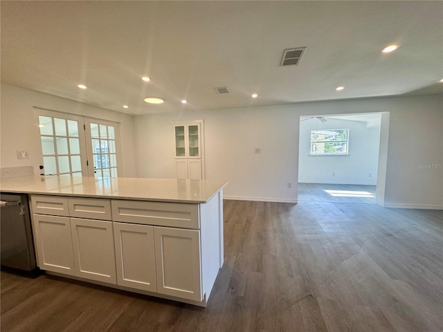 kitchen featuring dishwashing machine, dark hardwood / wood-style flooring, and white cabinets