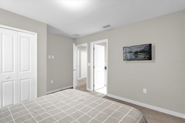 unfurnished bedroom with light carpet, baseboards, visible vents, and a closet