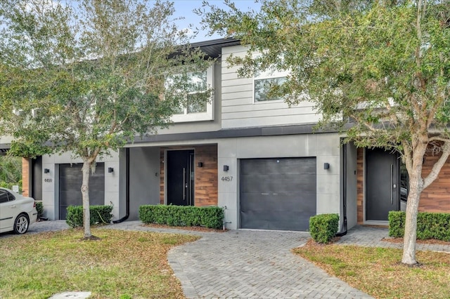 view of front of property with a garage and decorative driveway