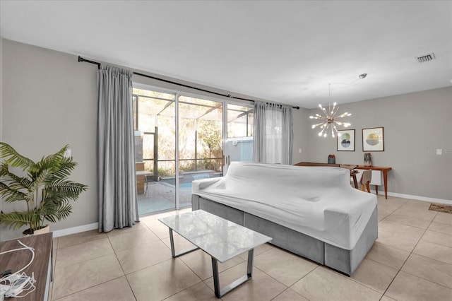 living room featuring light tile patterned floors, a notable chandelier, visible vents, and baseboards