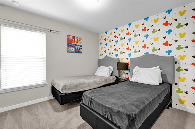 bedroom featuring light carpet, baseboards, and wallpapered walls