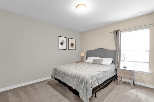 bedroom with light carpet and baseboards