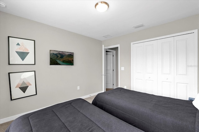 bedroom featuring a closet, baseboards, visible vents, and carpet flooring