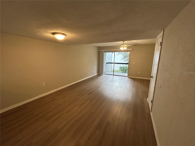 empty room featuring a textured ceiling, dark hardwood / wood-style floors, and ceiling fan