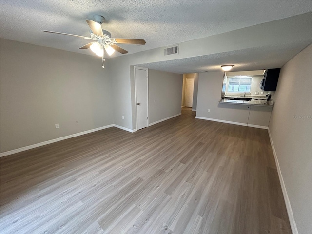 unfurnished room featuring hardwood / wood-style floors, a textured ceiling, and ceiling fan