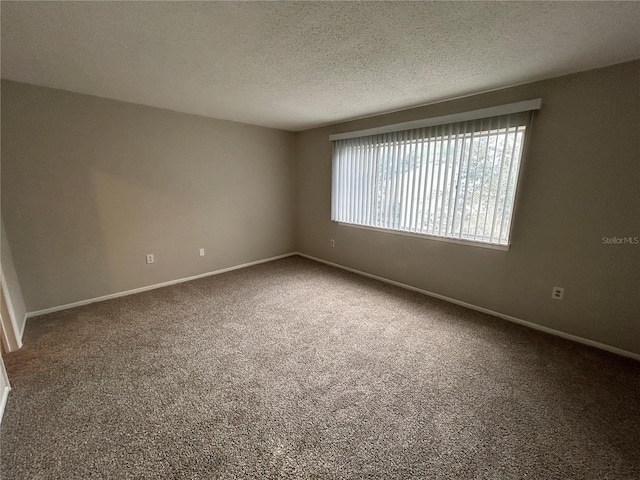 spare room featuring a textured ceiling and carpet floors