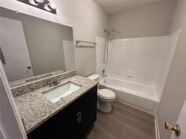 full bathroom featuring toilet, wood-type flooring, vanity, and bathing tub / shower combination