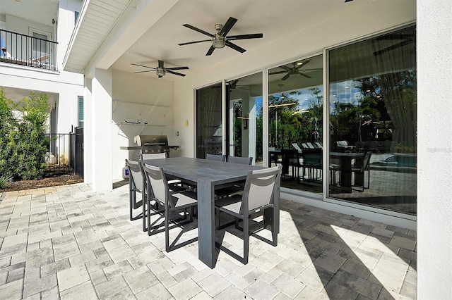 view of patio featuring ceiling fan, a grill, and a balcony