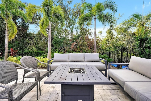 view of patio with an outdoor living space with a fire pit