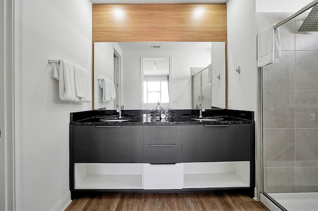 bathroom with hardwood / wood-style flooring, vanity, and an enclosed shower