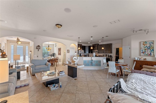 tiled living room with an inviting chandelier