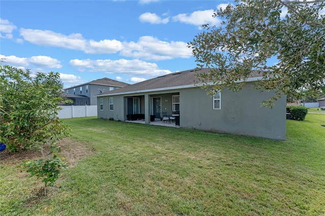 back of property featuring a lawn and a patio area