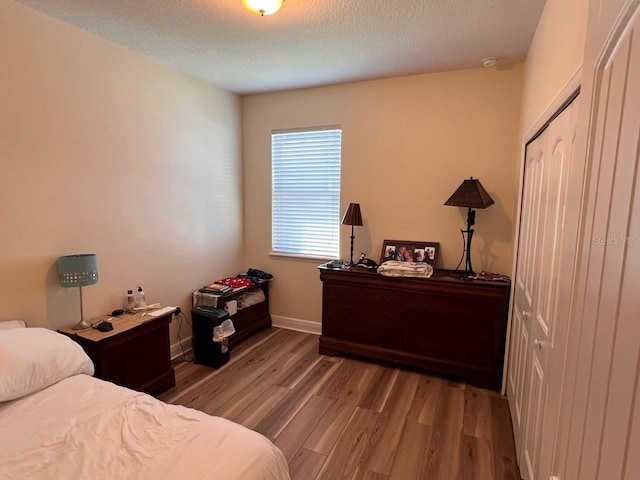 bedroom with hardwood / wood-style floors and a textured ceiling