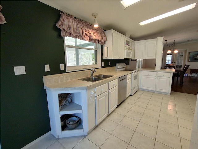 kitchen featuring white cabinets, white appliances, hanging light fixtures, and sink