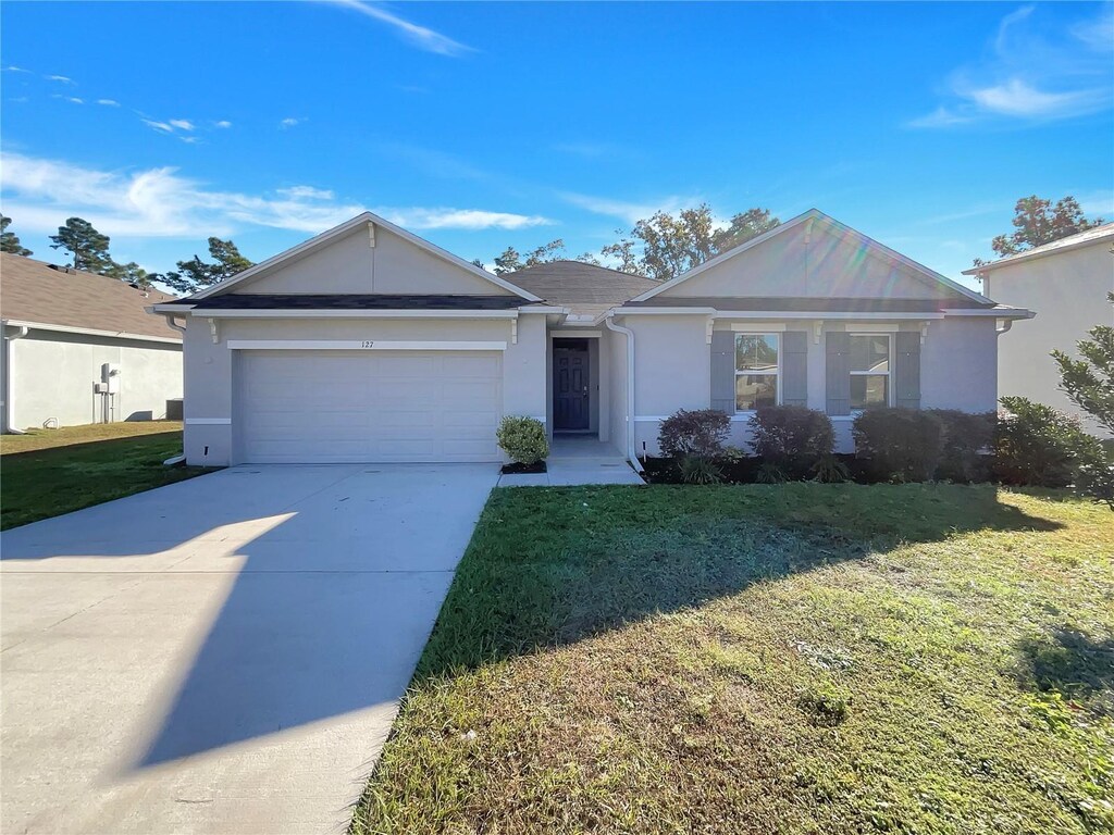 127 Hickory Crse, Ocala, FL 34472 - ranch-style house with stucco siding, an attached garage, a front yard, and concrete driveway
