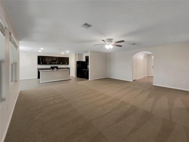 unfurnished living room with ceiling fan and light carpet