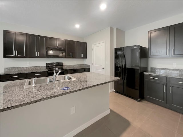 kitchen featuring light stone countertops, light tile patterned floors, sink, and black appliances