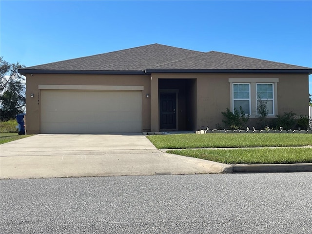 view of front of home with a garage and a front lawn